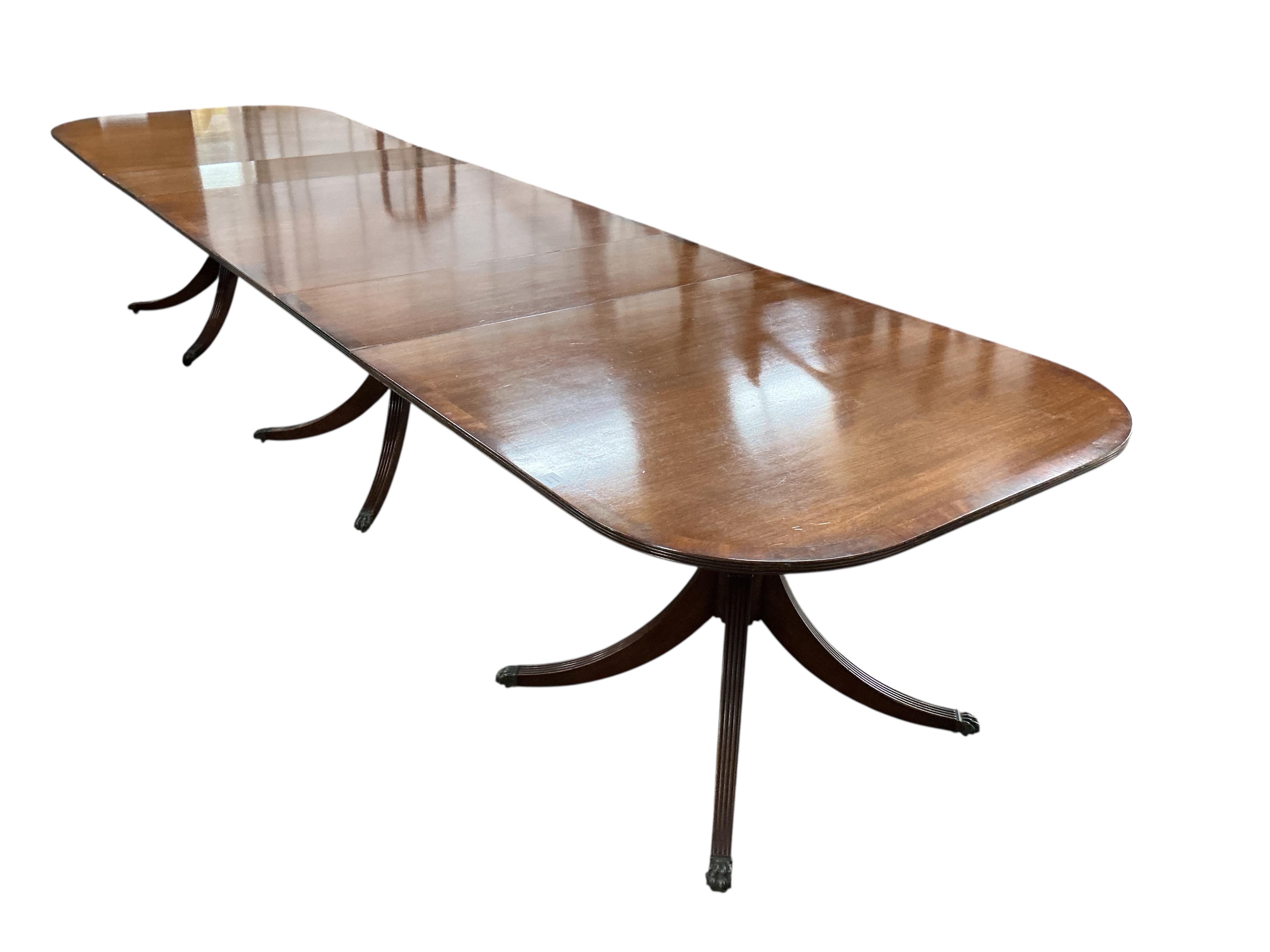A reproduction George III style mahogany triple pillar extending dining table, width 500cm extended, two spare leaves, depth 108cm, height 75cm